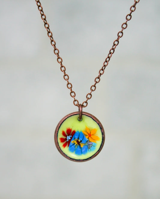 a necklace with a picture of flowers on it