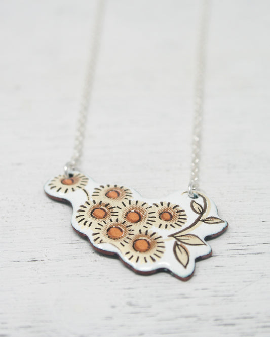 a silver necklace with orange flowers on it