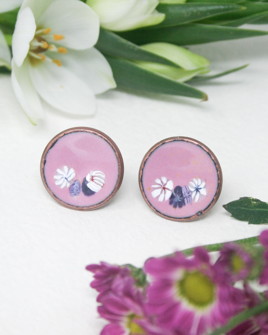 a pair of pink earrings with flowers on them
