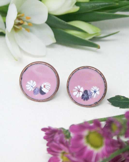 a pair of pink earrings with flowers on them