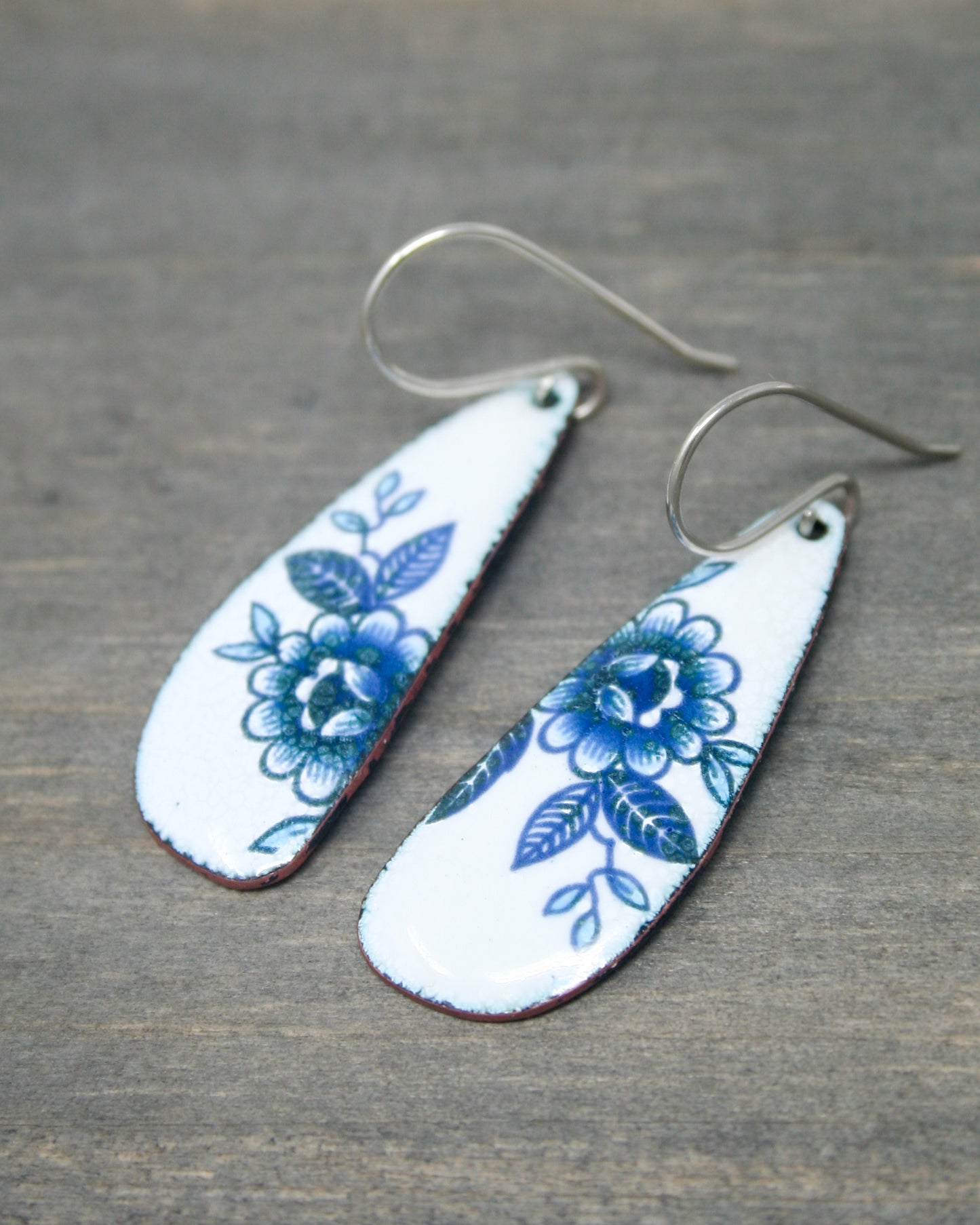 a pair of earrings with blue flowers on them