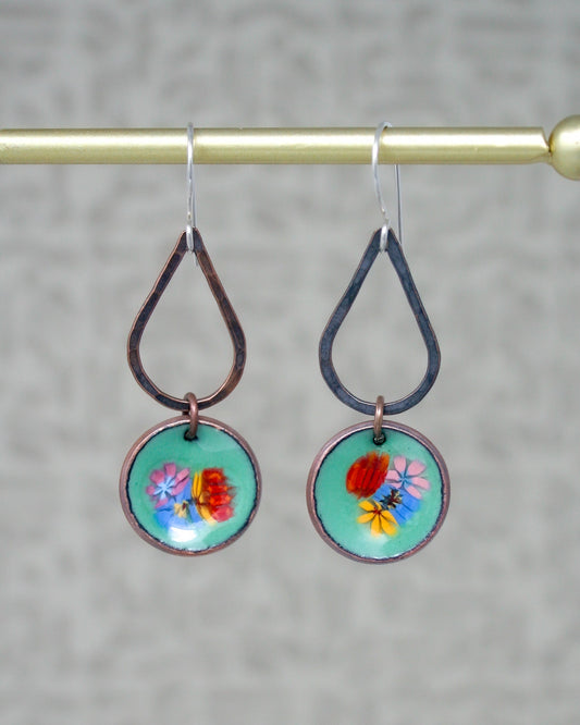 a pair of earrings hanging from a hook