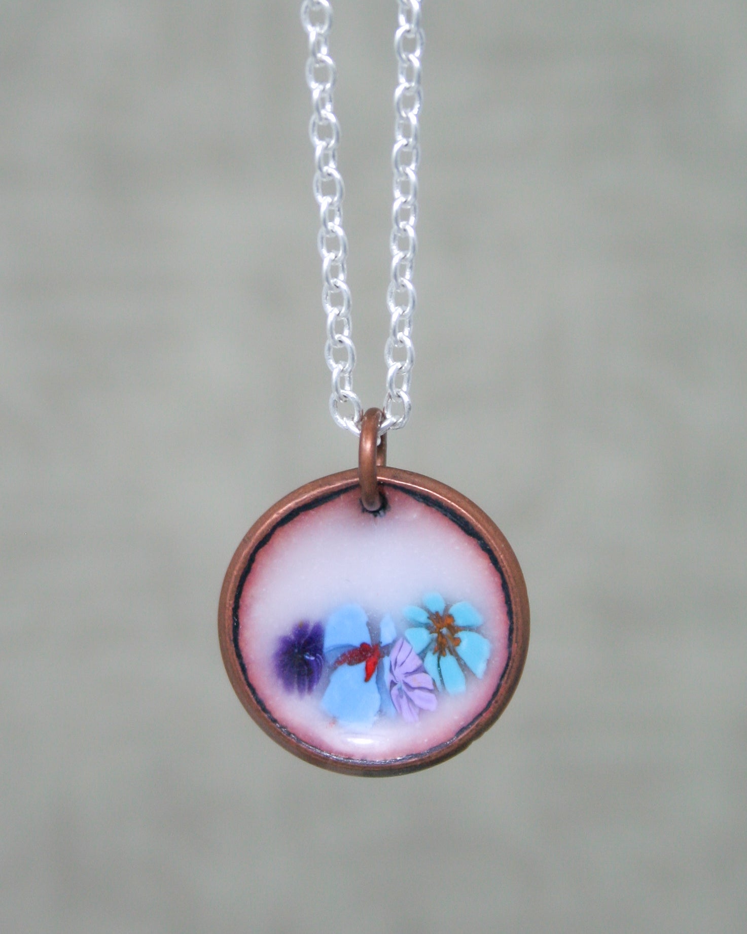 a necklace with a picture of flowers on it