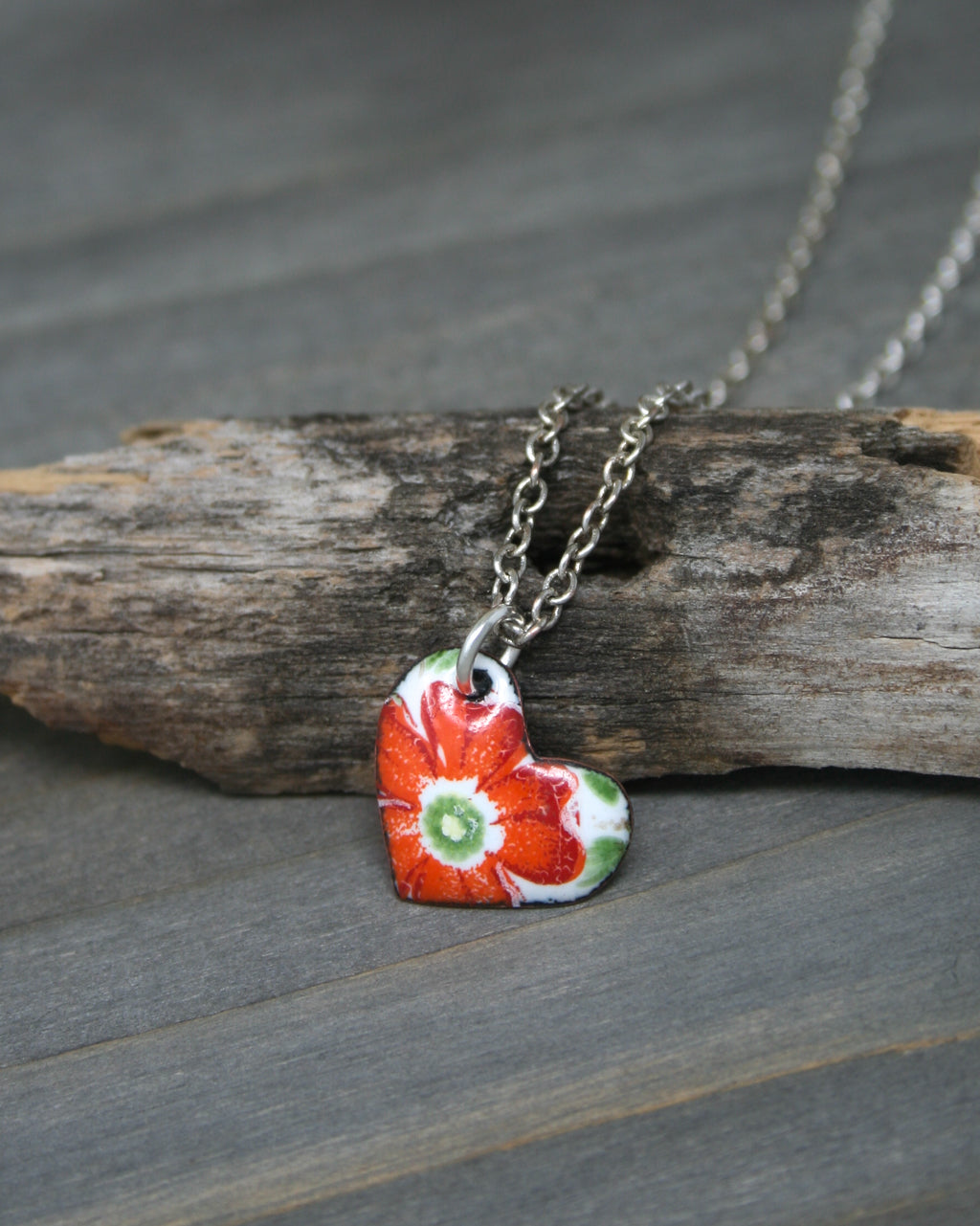 a necklace with a red flower on it