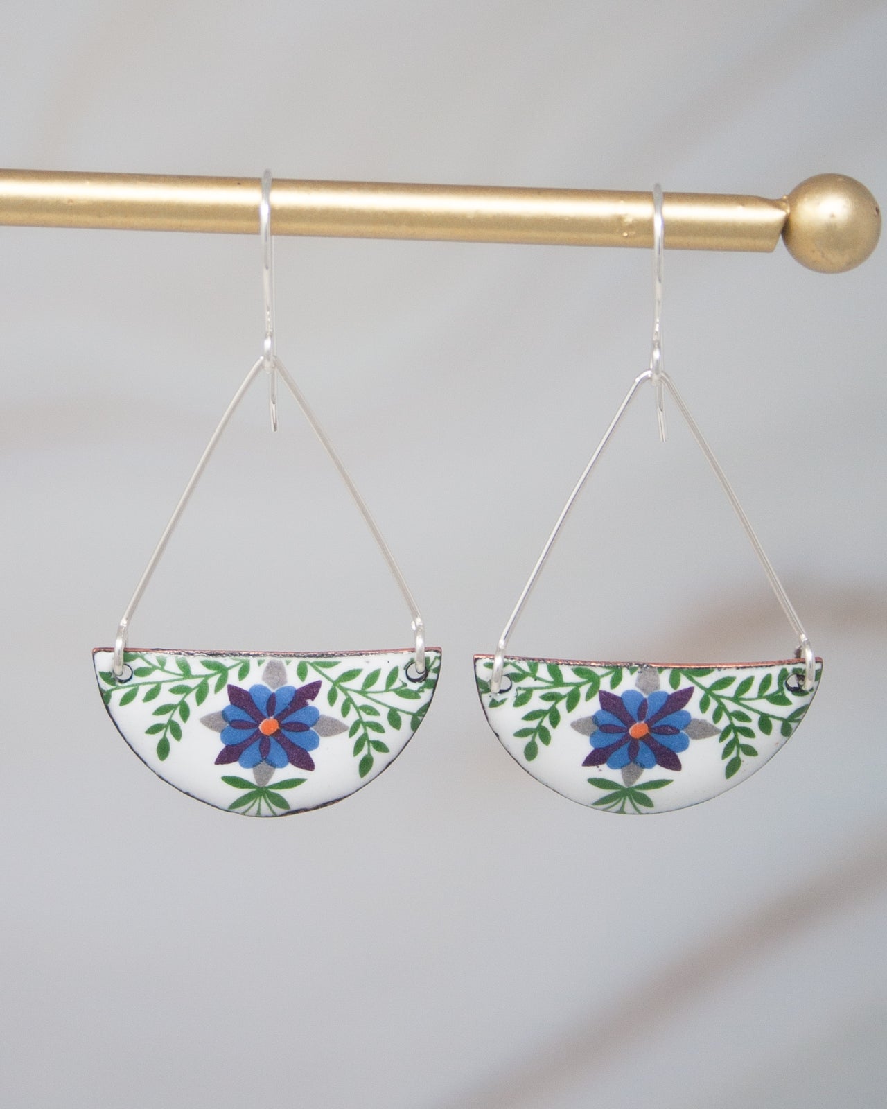 A pair of earrings with a floral design on a white background.