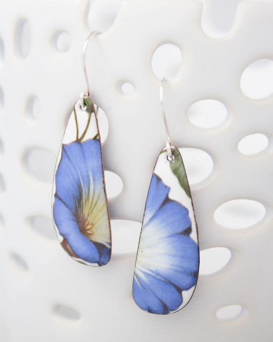 A pair of earrings with blue and yellow floral designs on them.