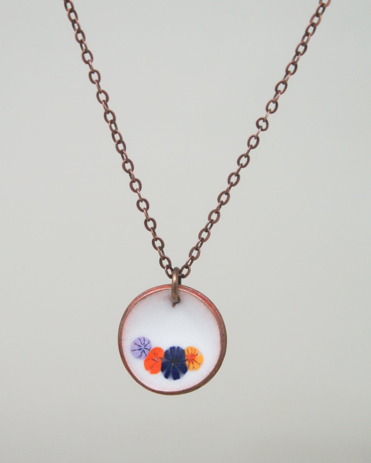 a necklace with three flowers on a chain
