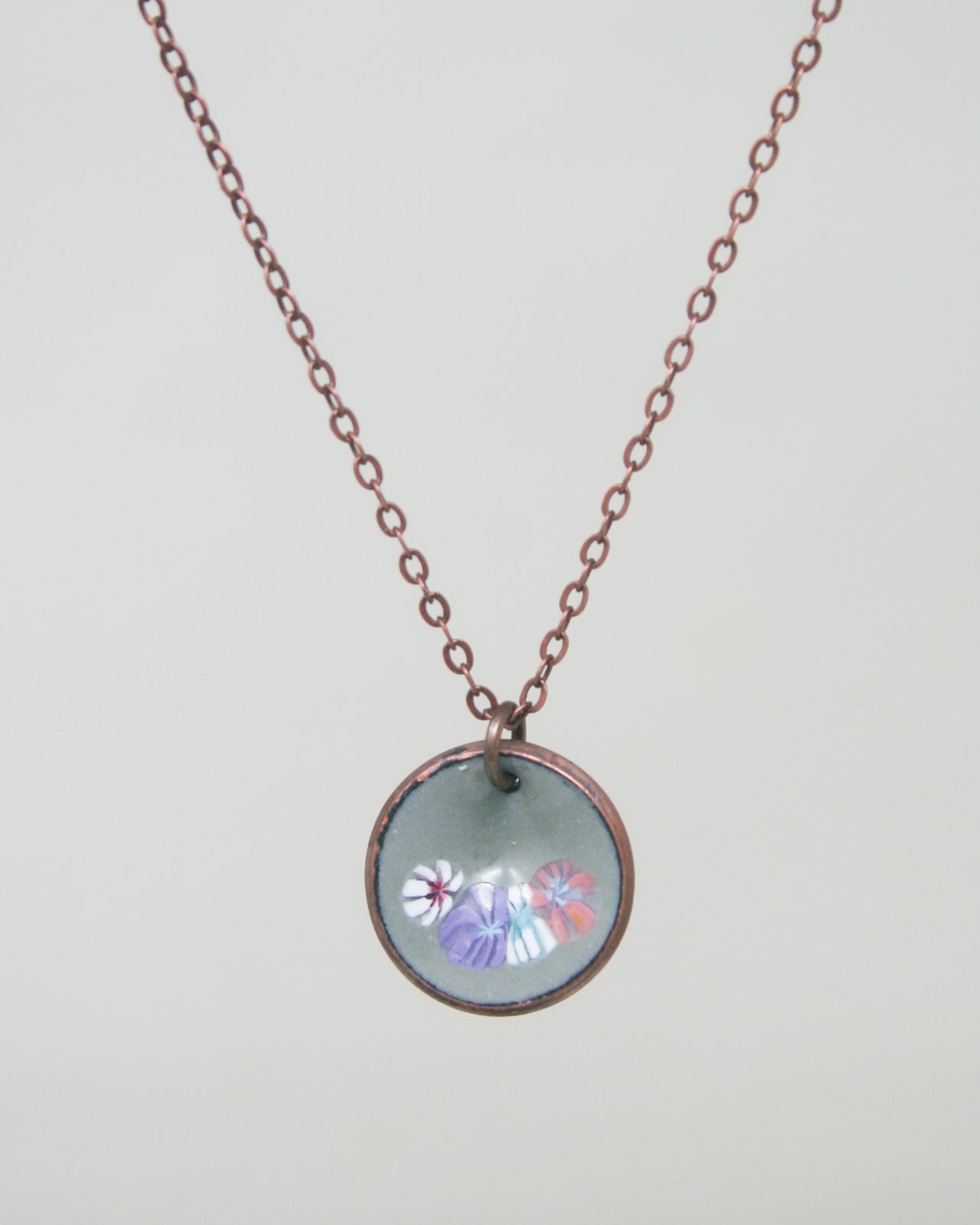 a necklace with a picture of flowers on it