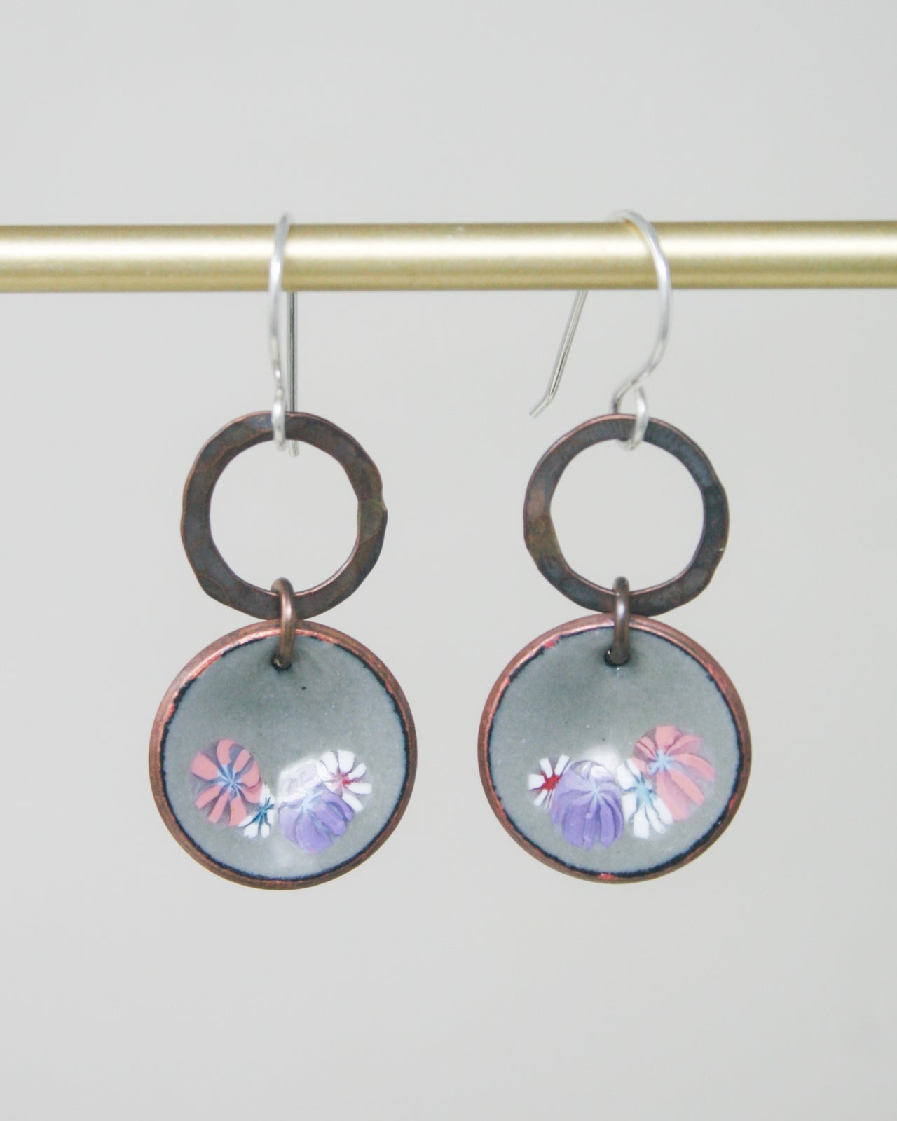 a pair of earrings hanging from a hook