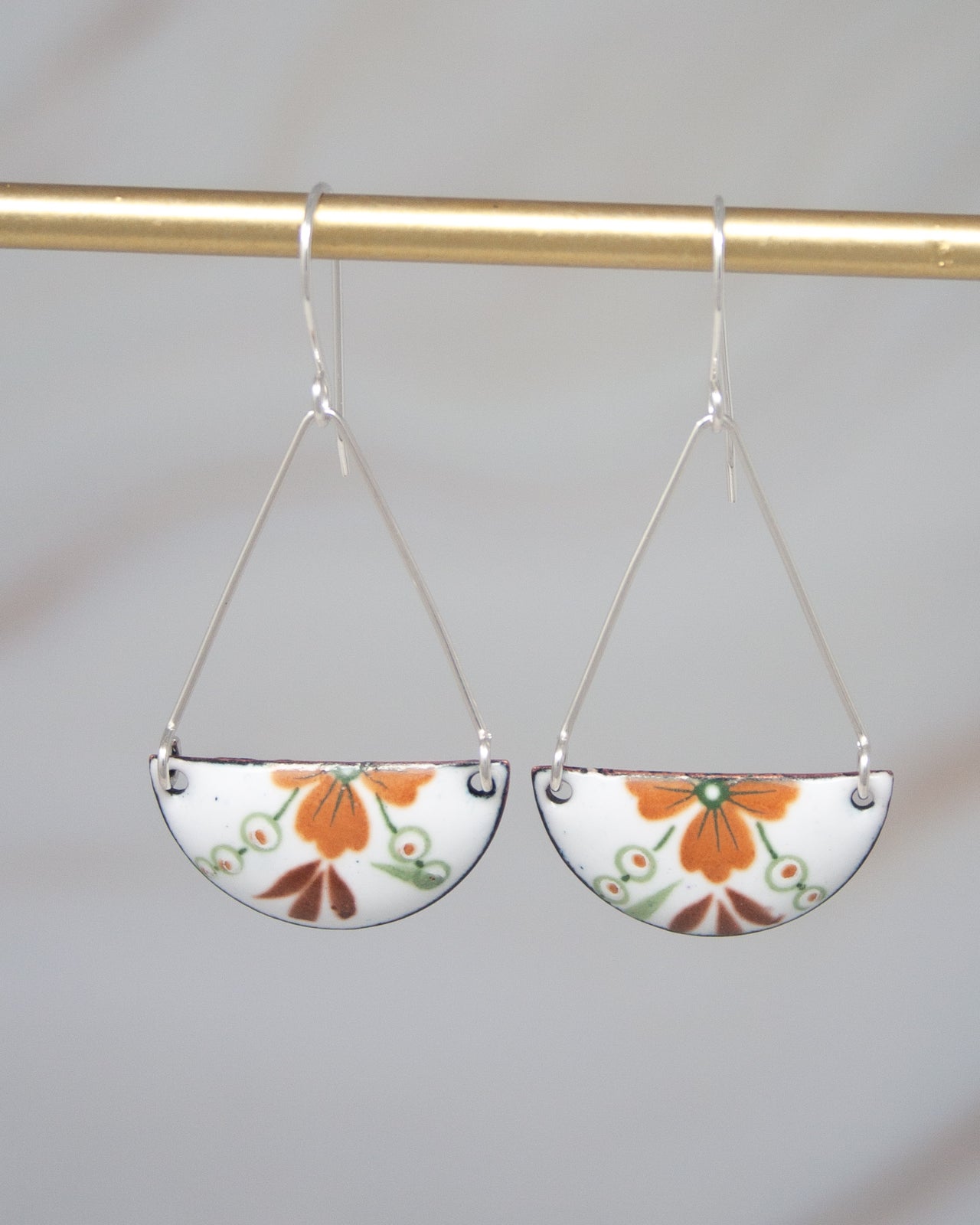 A pair of earrings with a floral design on a white background.