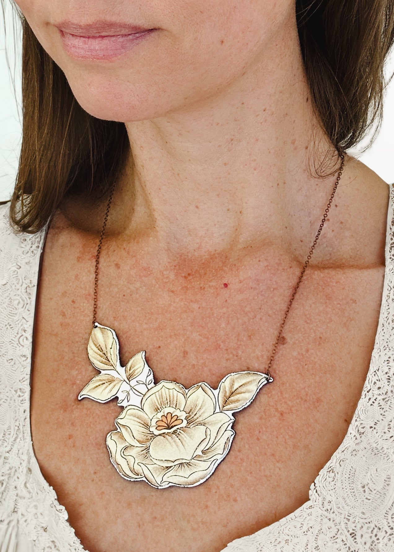 a close up of a woman wearing a necklace with flowers on it