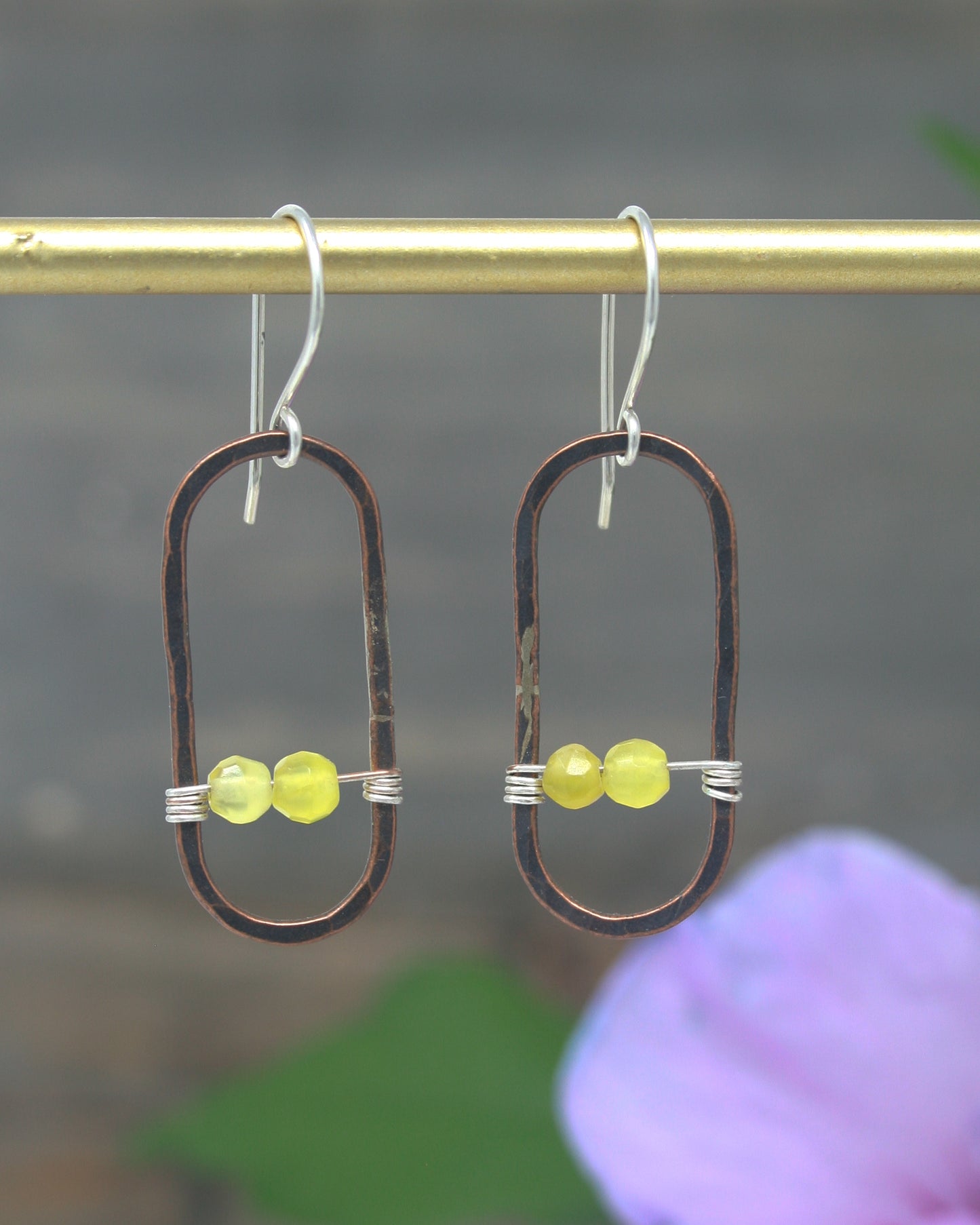 a pair of earrings with yellow beads hanging from a hook