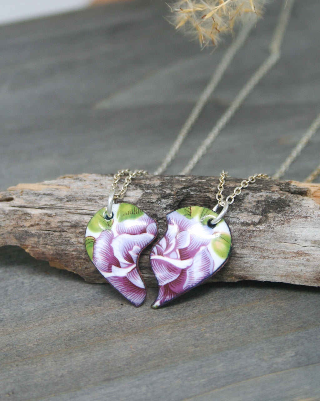 a couple of necklaces sitting on top of a piece of wood