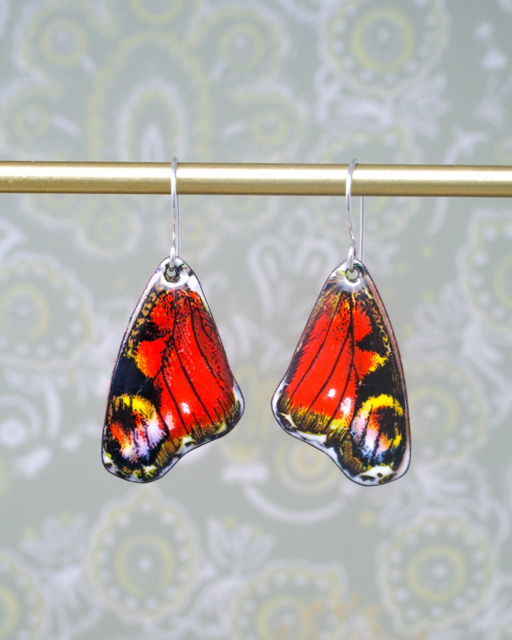 a pair of red and yellow butterfly earrings