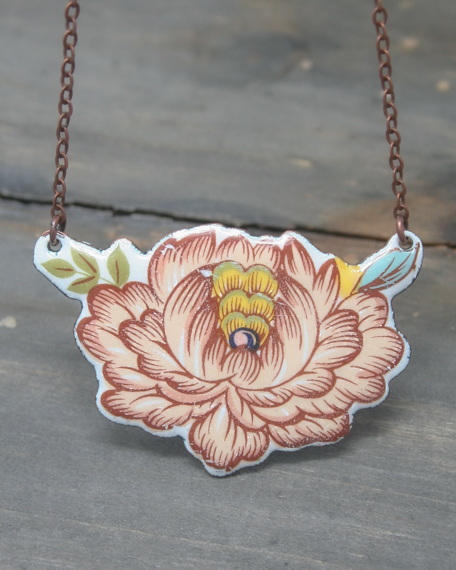 a necklace with a flower painted on it