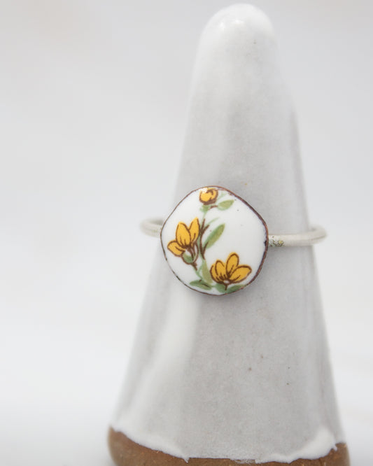 A white ceramic ring stand with a round, floral-patterned design on it.