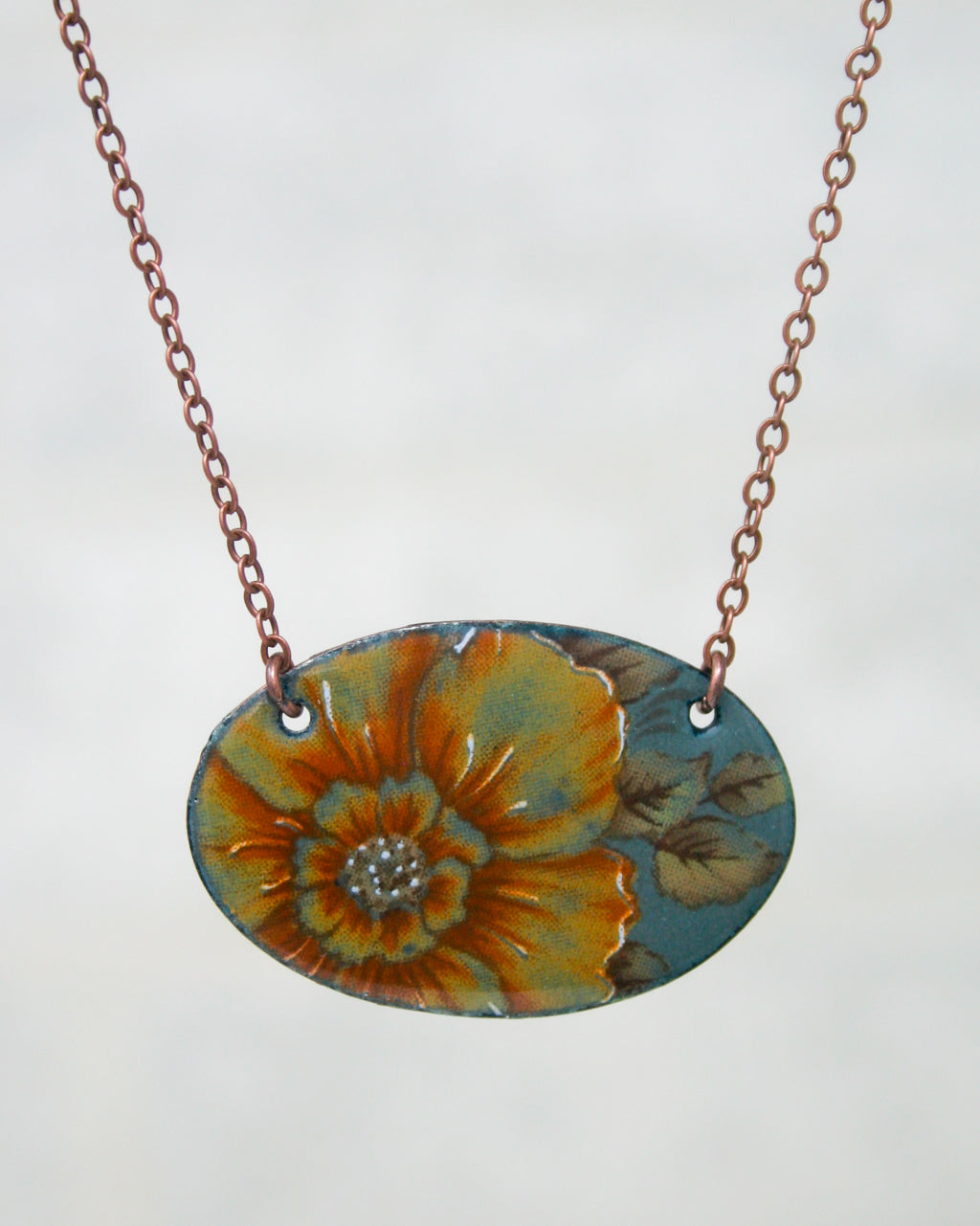 A necklace with a pendant featuring a large, colorful flower design.