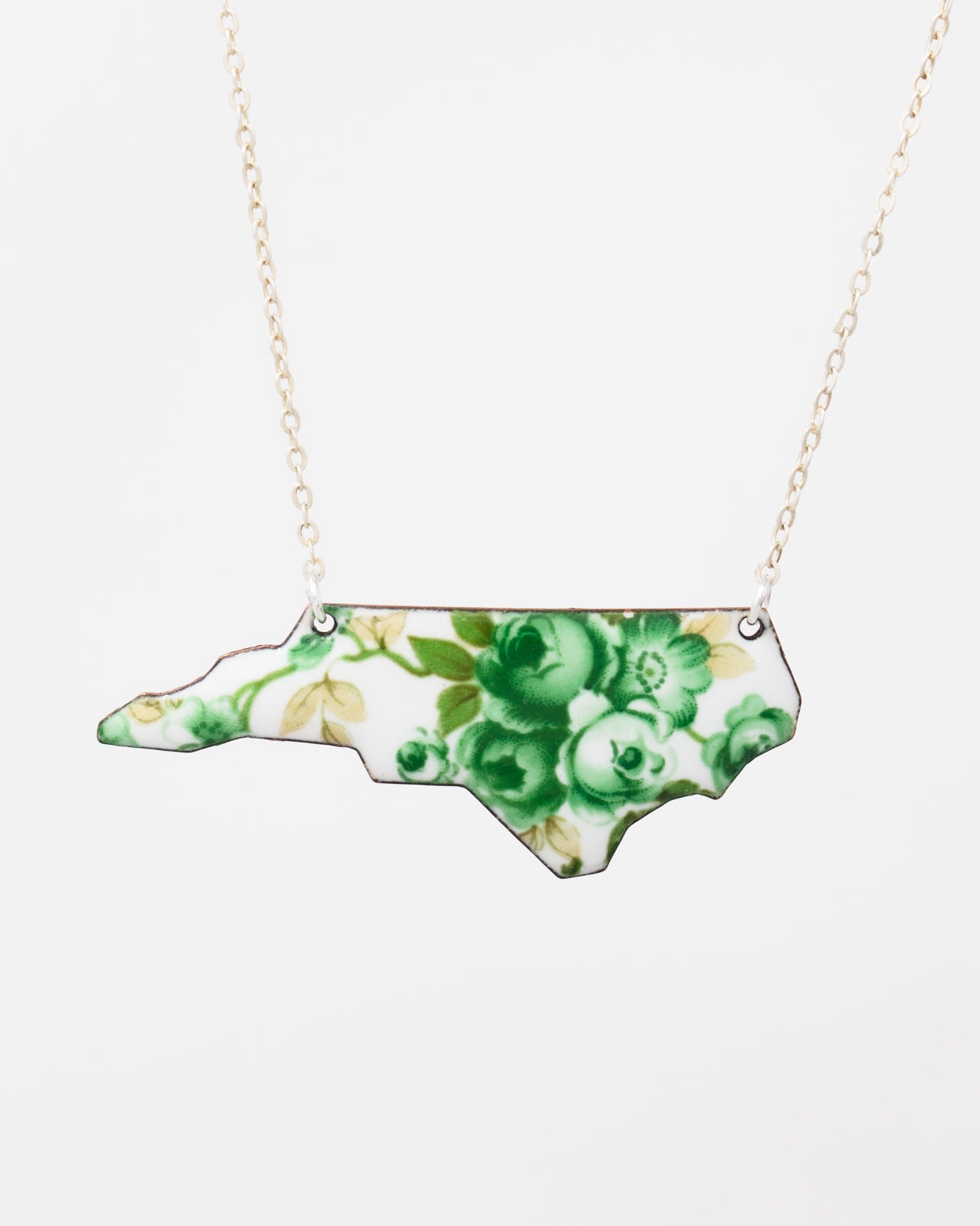 A necklace with a pendant in the shape of the state of North Carolina.