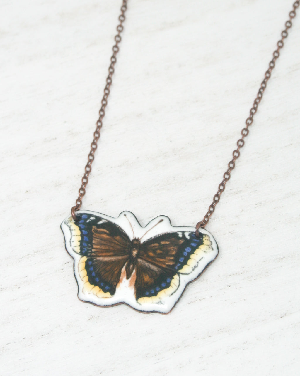 A necklace with a pendant in the shape of a butterfly.