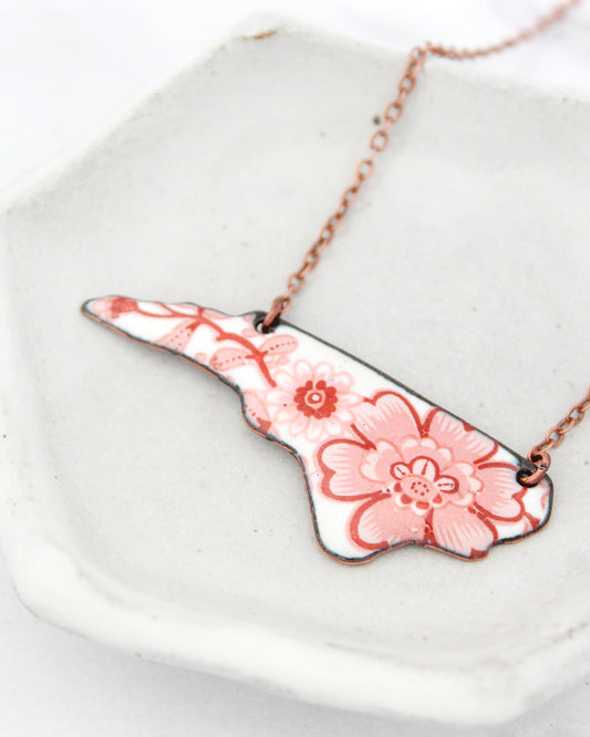 A necklace with a floral design in pink and white colors.