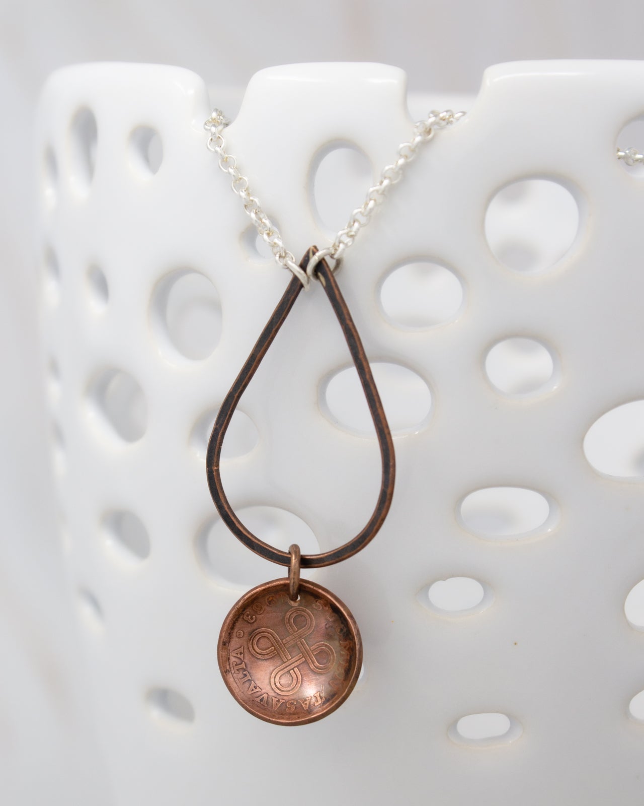 A necklace with a pendant featuring a circular design, hanging from a chain.
