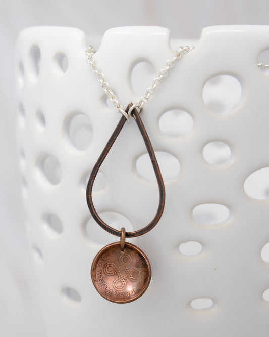 A necklace with a pendant featuring a circular design, hanging from a chain.