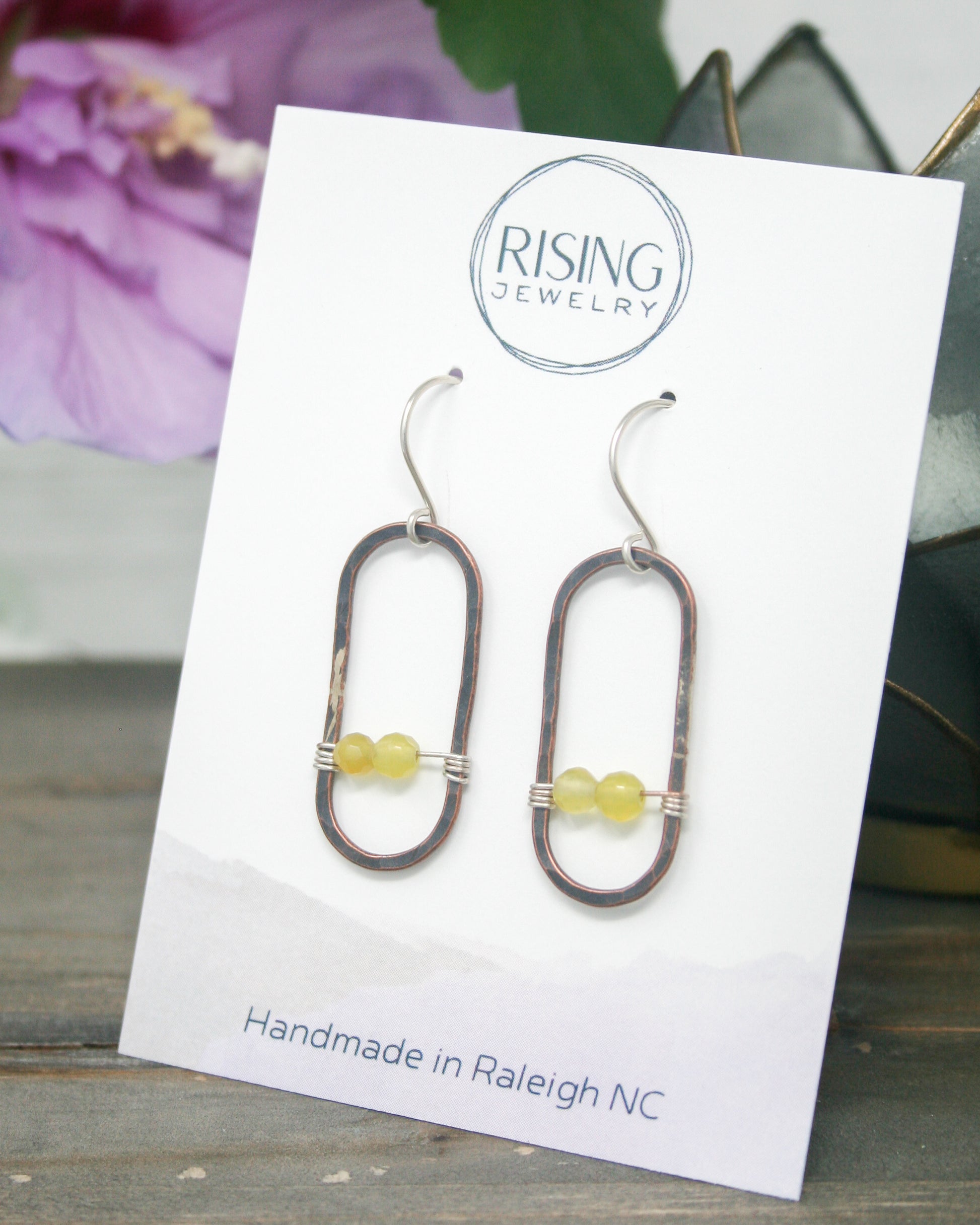 a pair of earrings sitting on top of a card