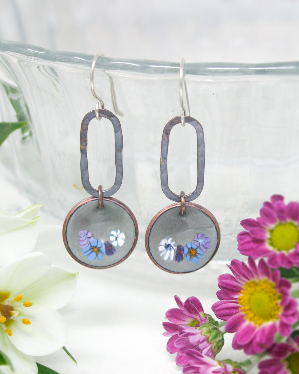 a pair of earrings with flowers on them