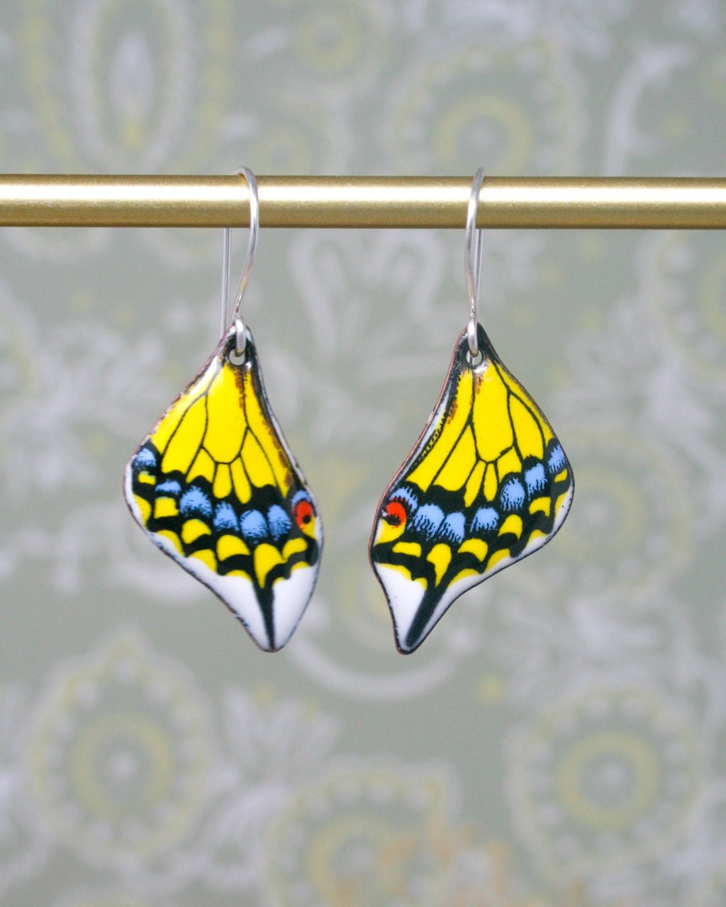 a pair of yellow and blue butterfly shaped earrings