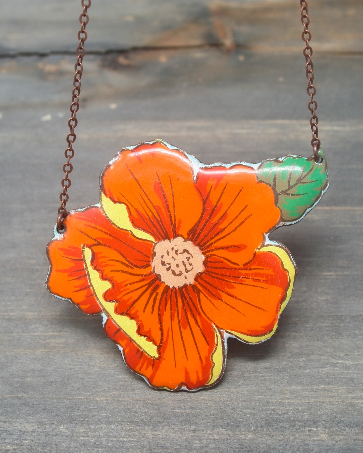 an orange flower is hanging from a chain