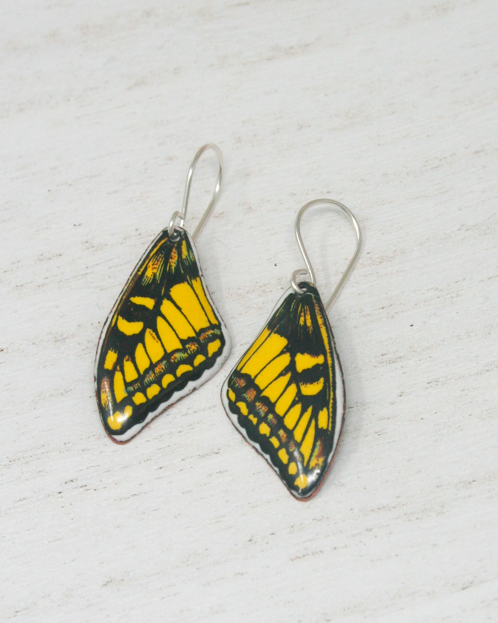 a pair of yellow and black butterfly earrings