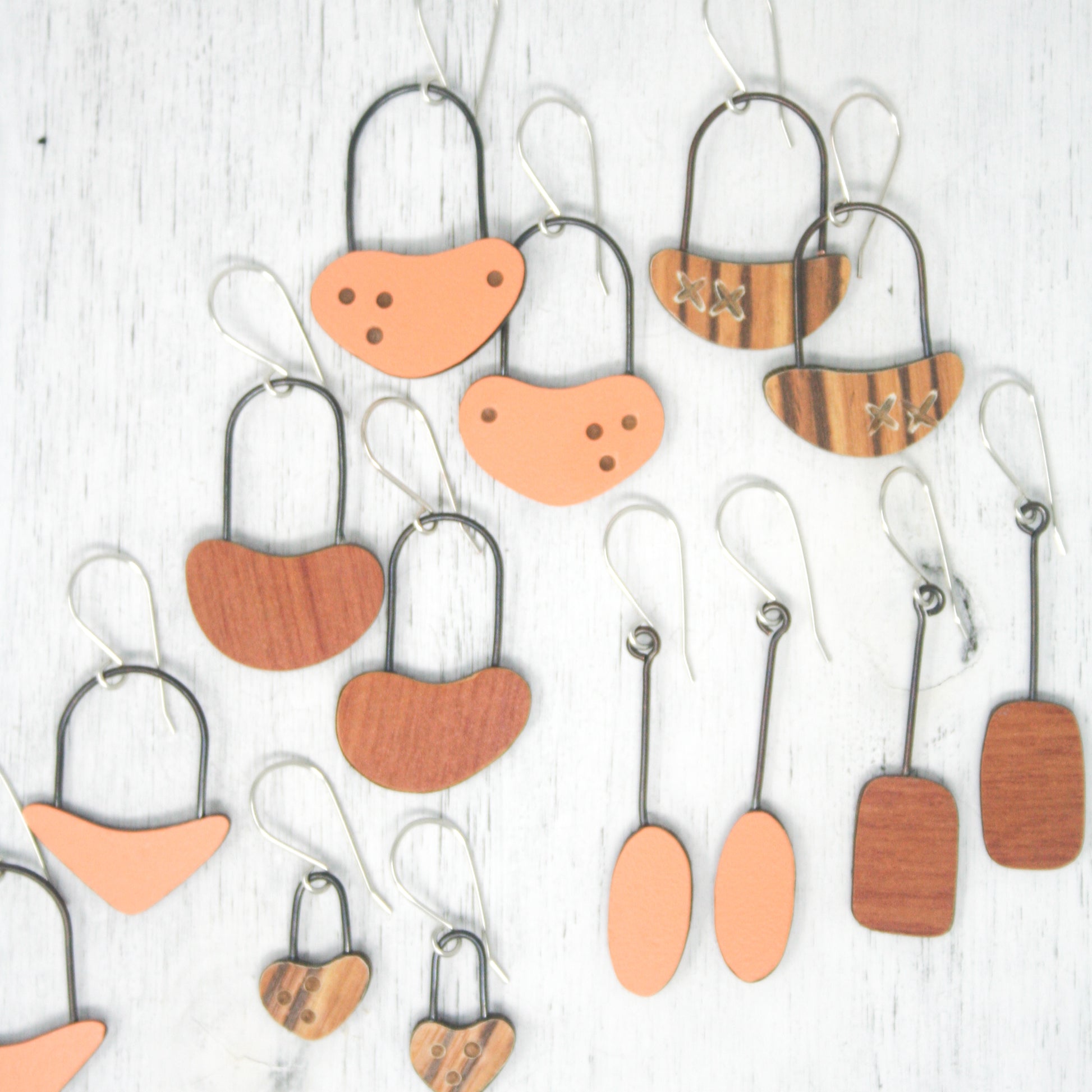 a group of wooden earrings hanging from hooks