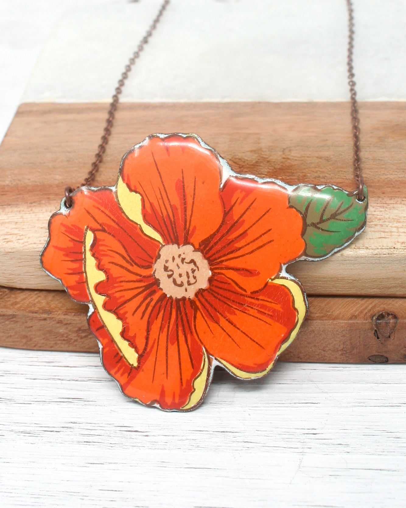 an orange flower is hanging from a chain