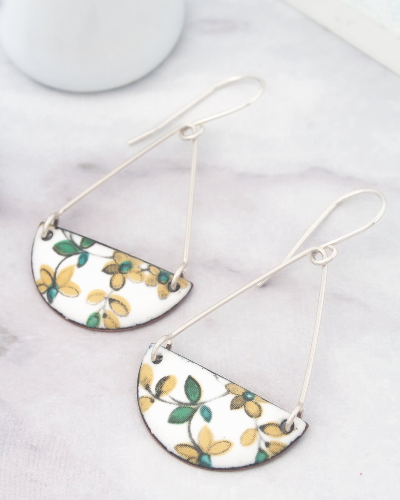 A pair of earrings with a floral design on a white background.