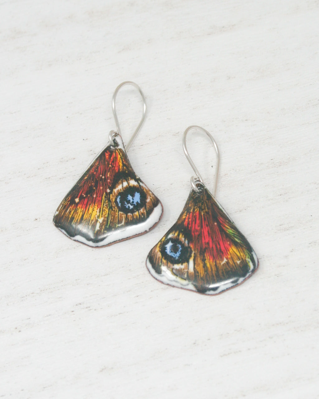 a pair of earrings with a butterfly design