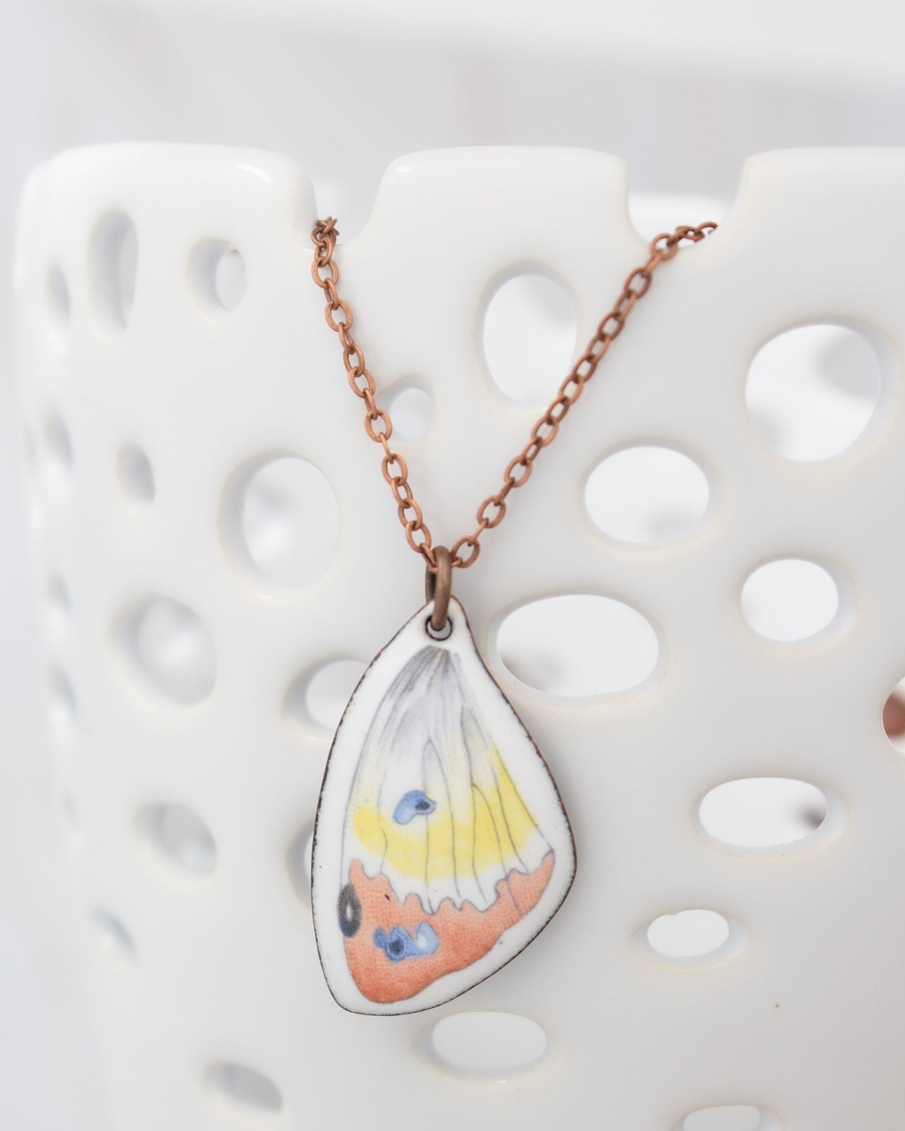 A necklace with a pendant featuring a colorful butterfly design.