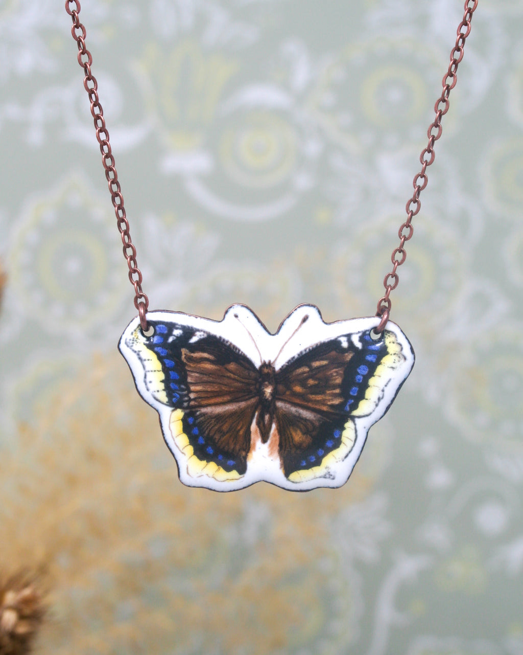 A necklace with a pendant in the shape of a butterfly.