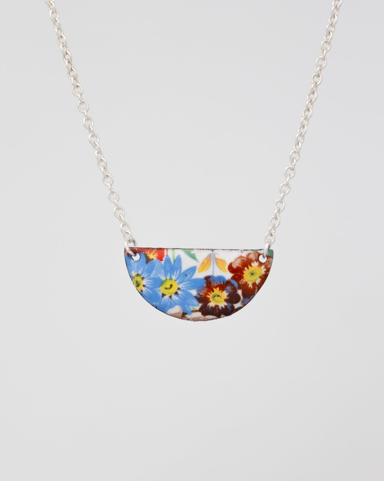 A necklace with a pendant featuring a colorful floral design.