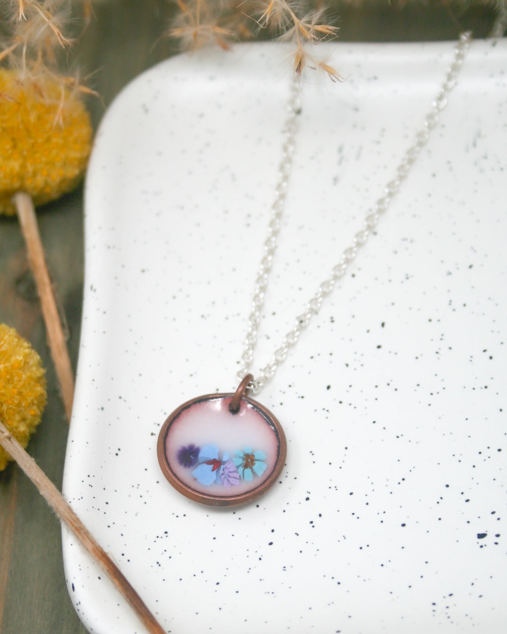 a necklace with a picture of a flower on it