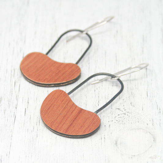 a pair of wooden heart shaped earrings on a white background