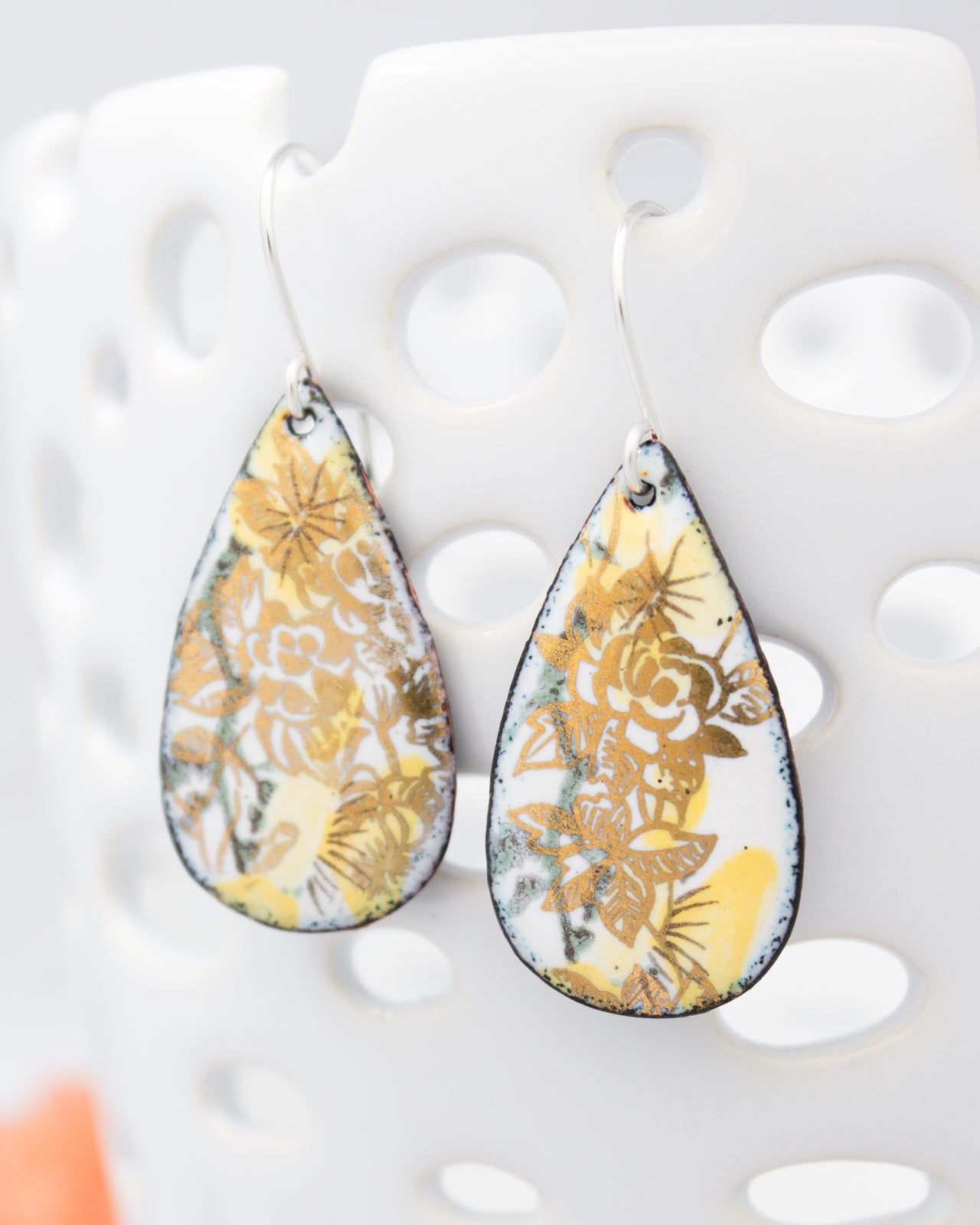 A pair of earrings with a floral design on a white background.