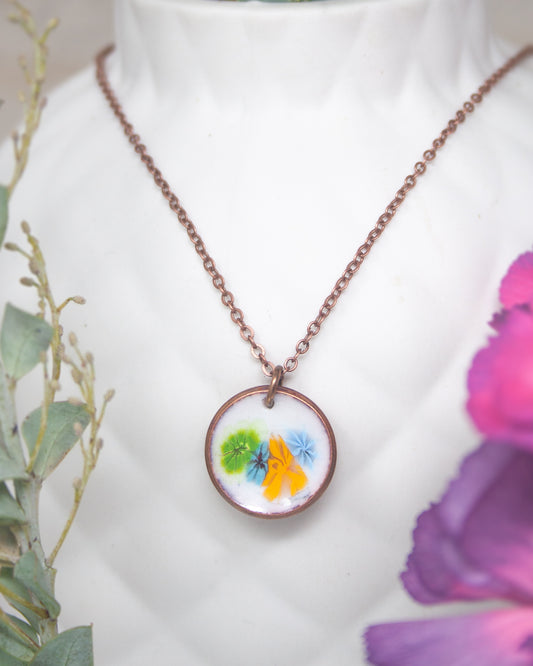 A necklace with a circular pendant featuring a colorful floral design.