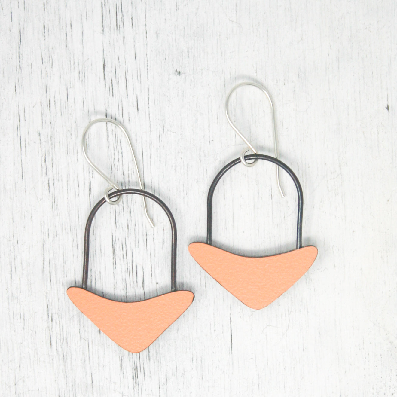 a pair of pink and black earrings on a white background