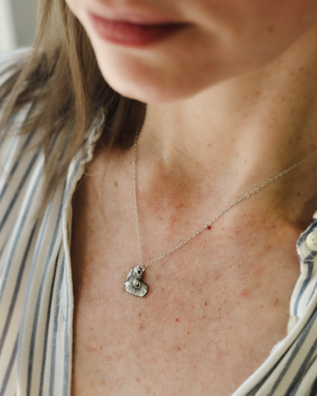 a close up of a woman wearing a necklace