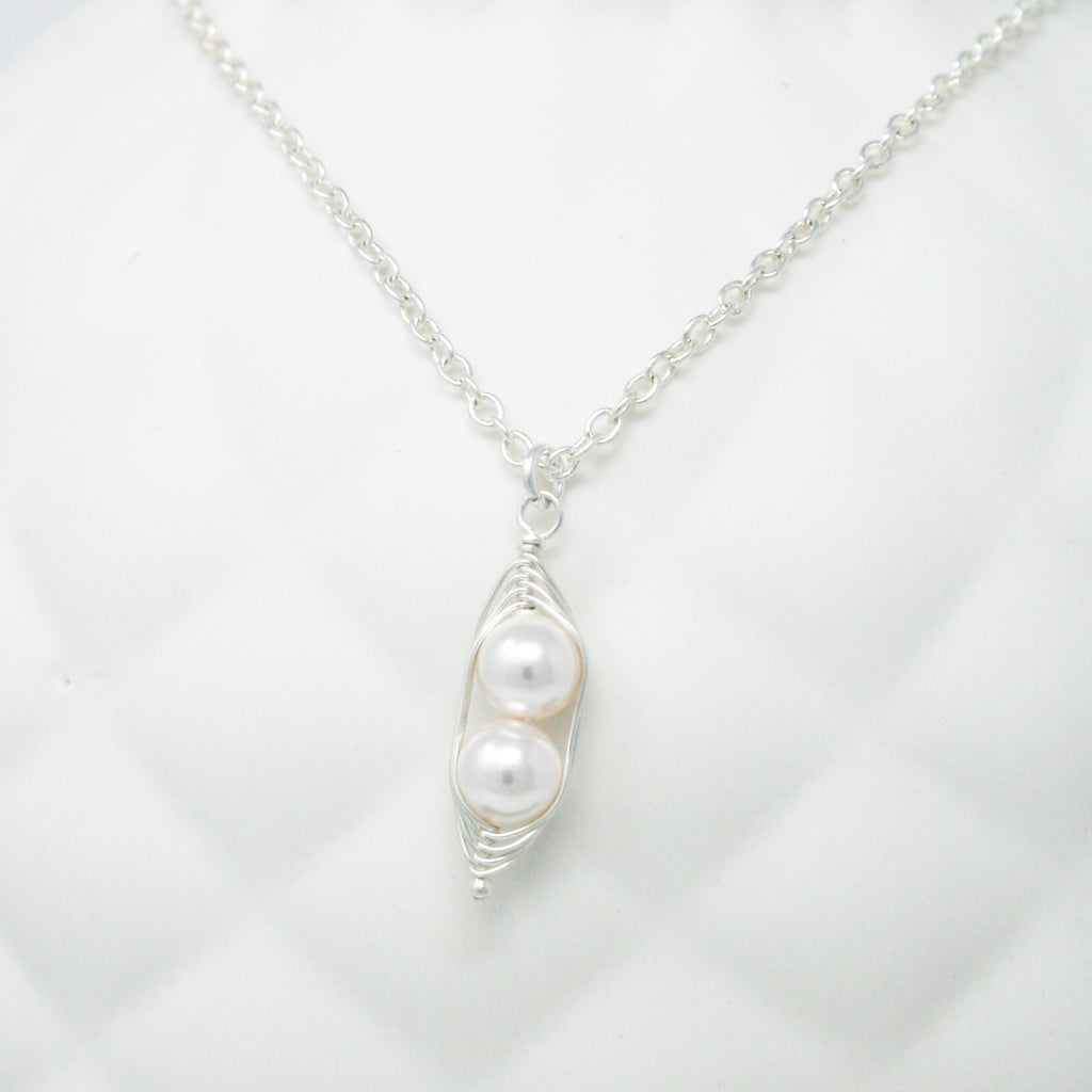a white necklace with a pearl hanging from it