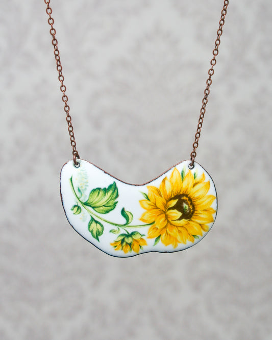 a necklace with a sunflower painted on it