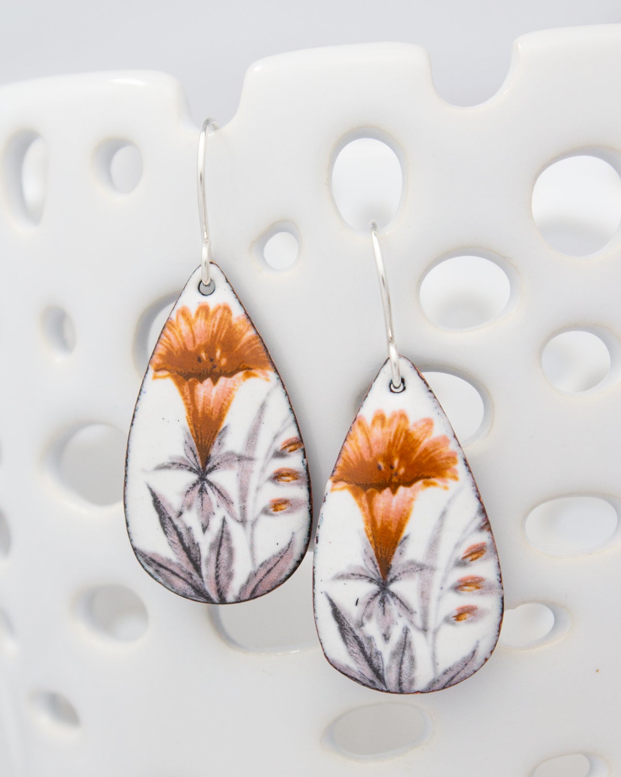 A pair of earrings with a floral design on a white background.