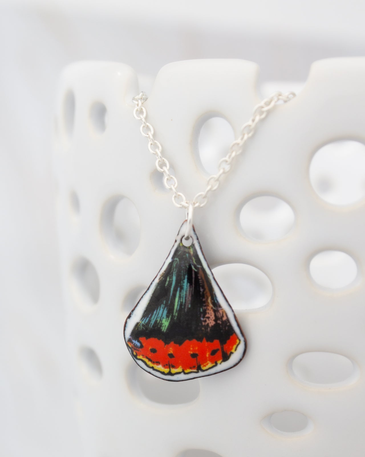 A necklace with a pendant featuring a colorful butterfly design.