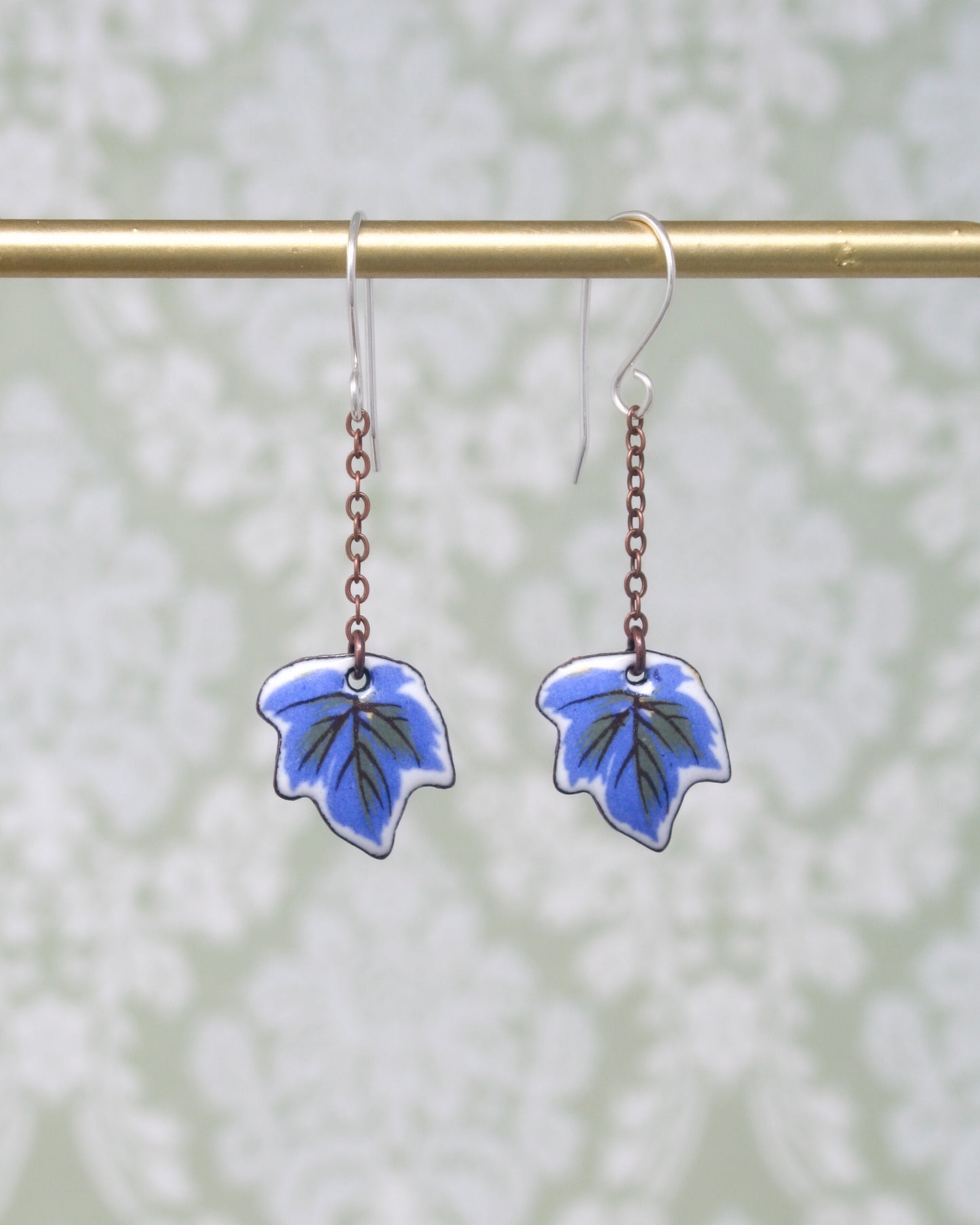 a pair of earrings with a blue flower on them