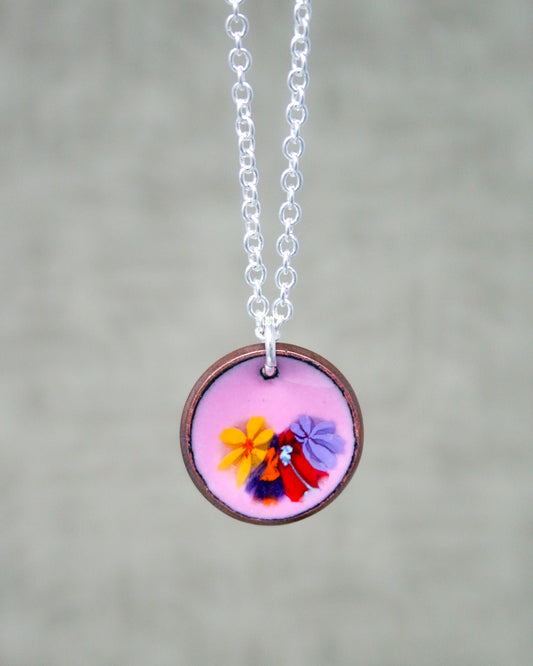 a necklace with a picture of a woman holding a flower